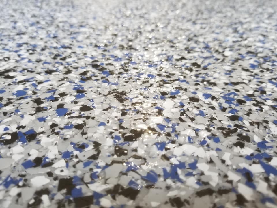 Full-broadcast flake epoxy floor — blue, black, and white chip blend with gloss topcoat, Long Island NY