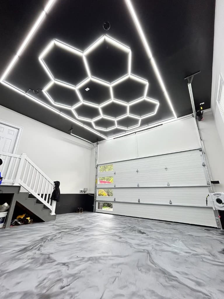 Garage floor with gray and white metallic epoxy swirl, hexagonal LED ceiling lights — Long Island NY